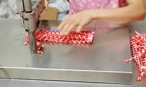 Polymer clay rods being cut into shorter sections